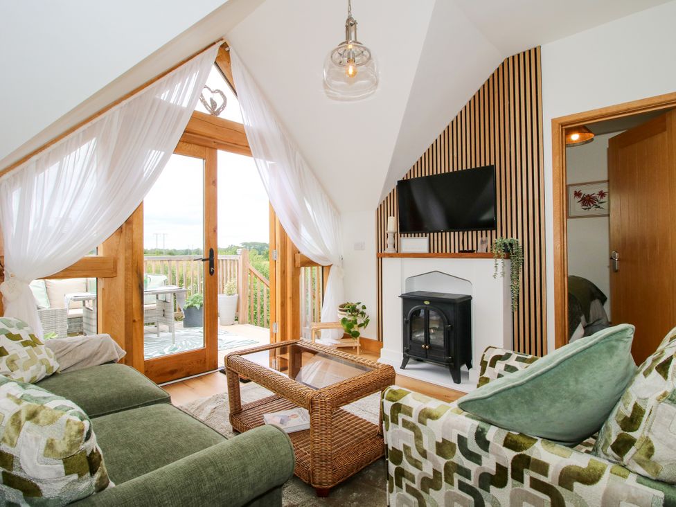 A living room with patio doors and a fireplace at Little Acre in Leominster