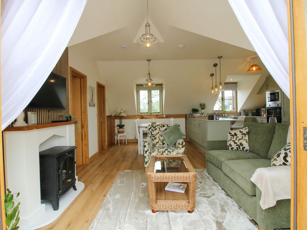 A living room with a sofa, coffee table, and fireplace at Little Acre in Leominster