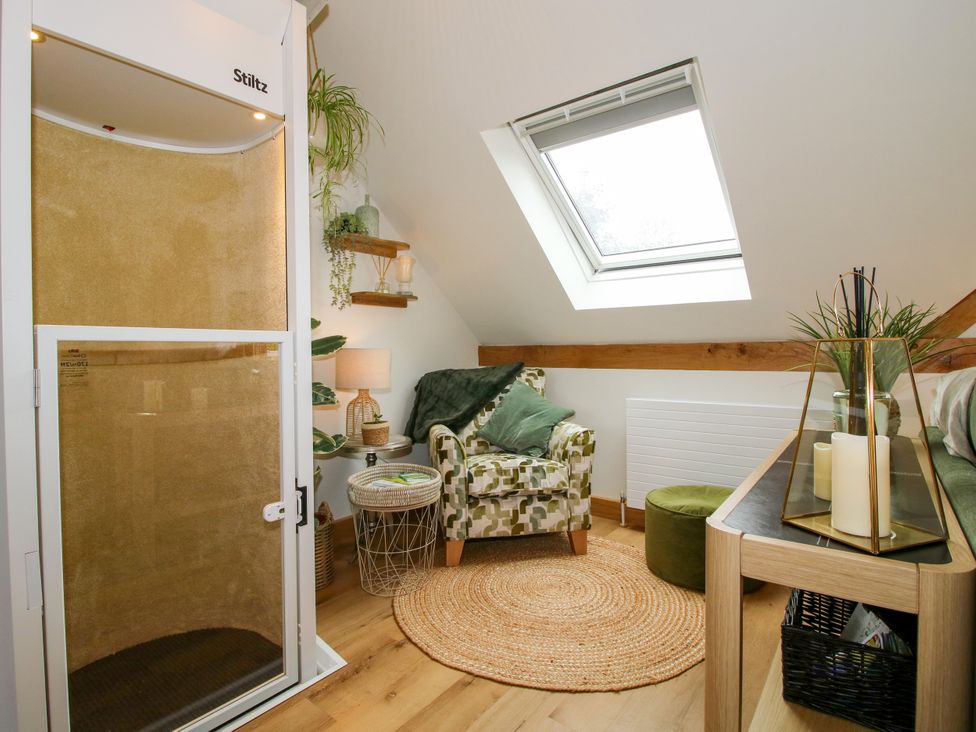 A living room with a shower and an armchair at Little Acre in Leominster