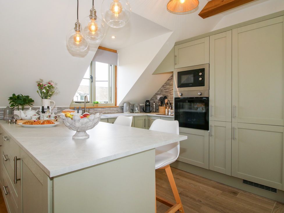 A kitchen with cabinets and appliances at Little Acre Leominster