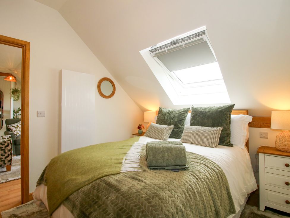 A bedroom with a bed, pillows, and a bedside table at Little Acre in Leominster