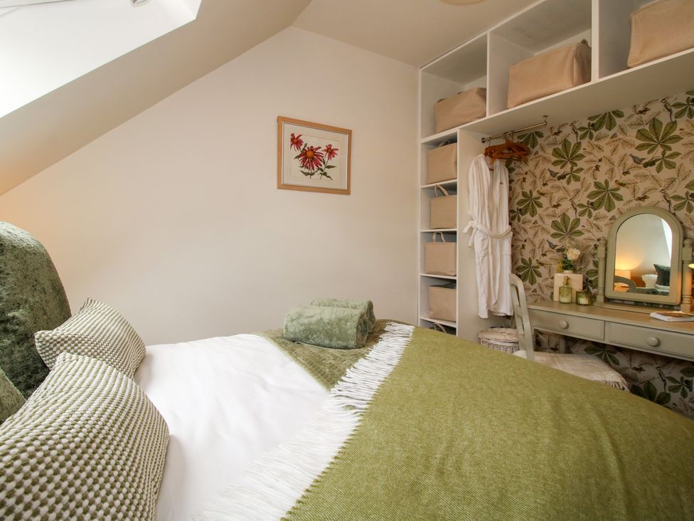 A bedroom with a bed and storage shelves at Little Acre in Leominster