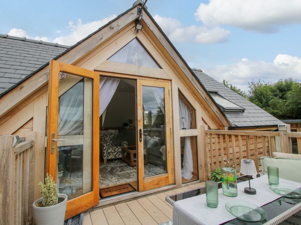 A balcony with double doors and a table with chairs at Little Acre in Leominster