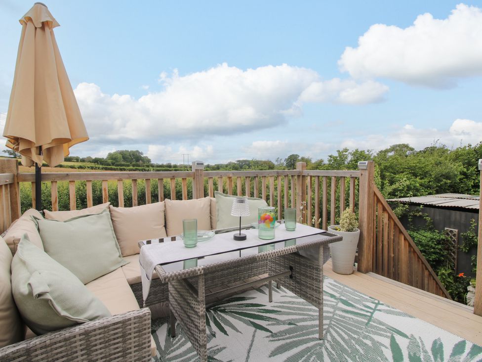 An outdoor seating area with a sofa and coffee table at Little Acre Leominster