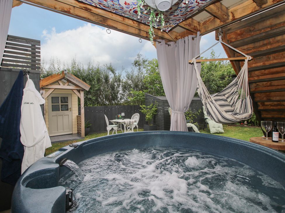 A garden with a hot tub and hammock at Little Acre in Leominster