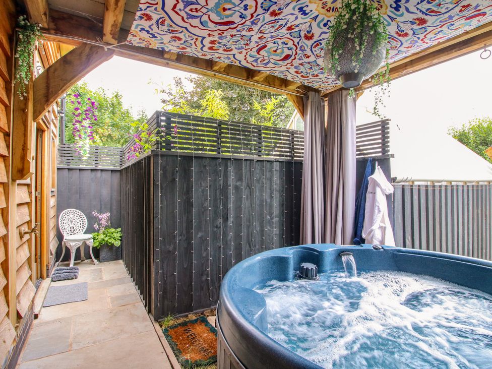 An outdoor area with a hot tub and chair at Little Acre in Leominster