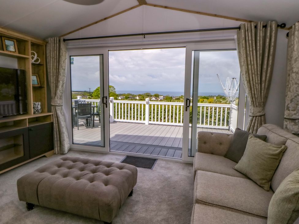 A living room with a sofa and television at The Dorchester at Bay View in New Quay