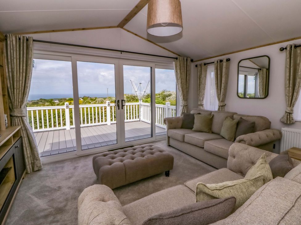 A living room with windows and a sofa at The Dorchester at Bay View, New Quay