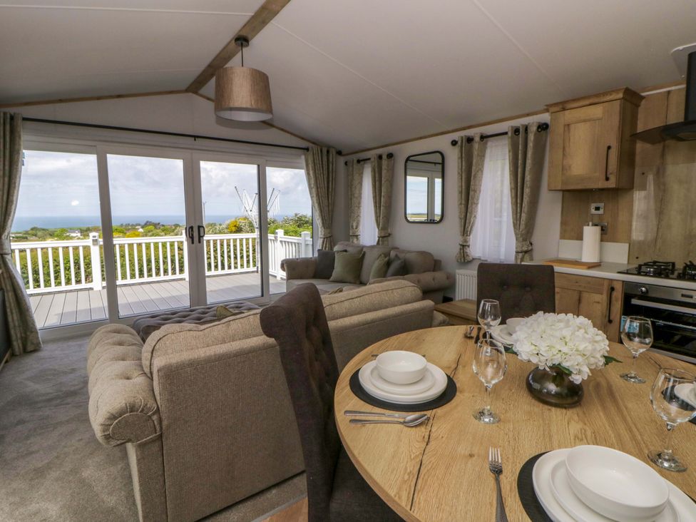 A living room with dining table and sofa at The Dorchester at Bay View in New Quay