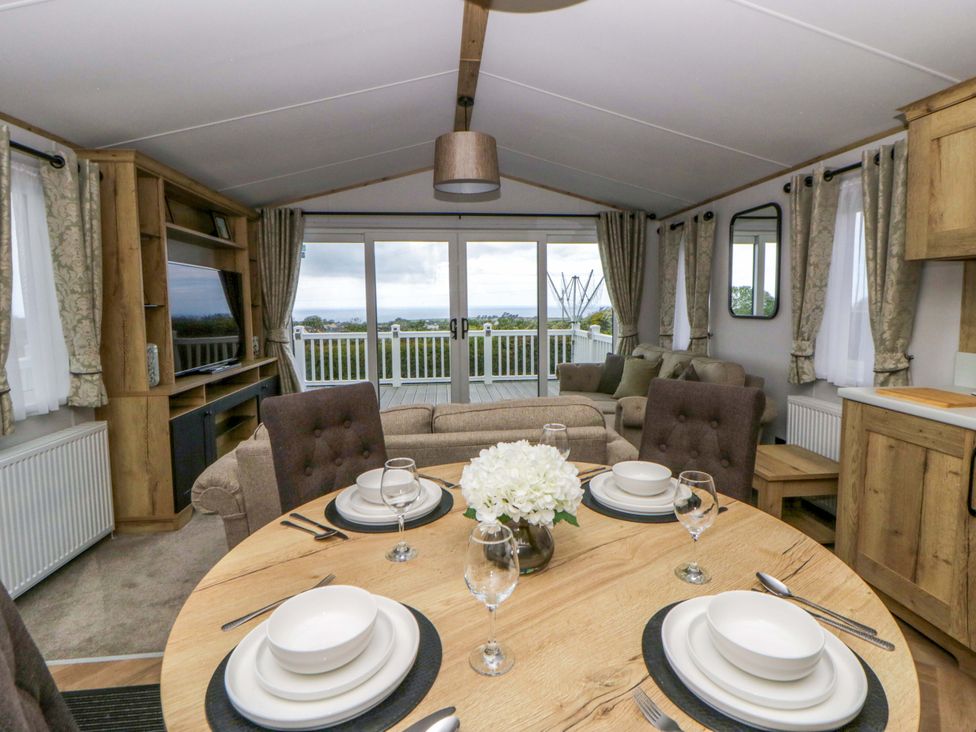 A dining room with a table set for meals at The Dorchester at Bay View New Quay