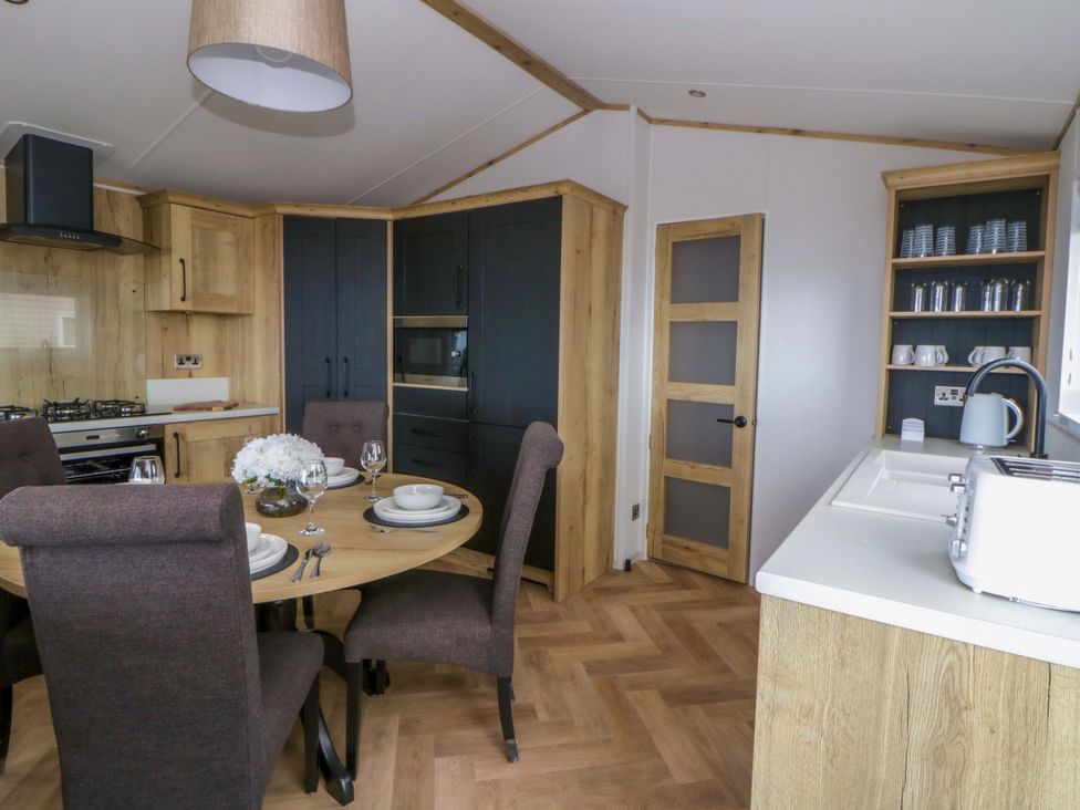 A kitchen with a dining area and appliances at The Dorchester at Bay View New Quay