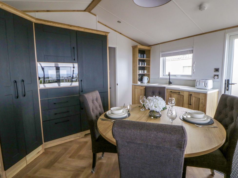 A dining room with a table set for a meal at The Dorchester at Bay View New Quay
