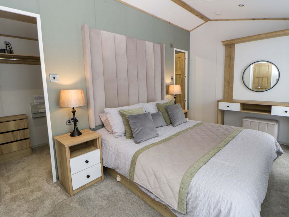 A bedroom with a bed and furniture at The Dorchester at Bay View in New Quay