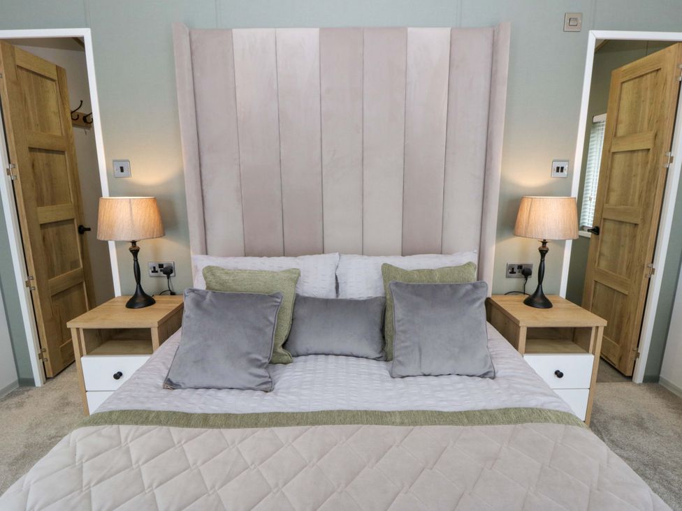 A bedroom with a bed and lamps at The Dorchester at Bay View New Quay