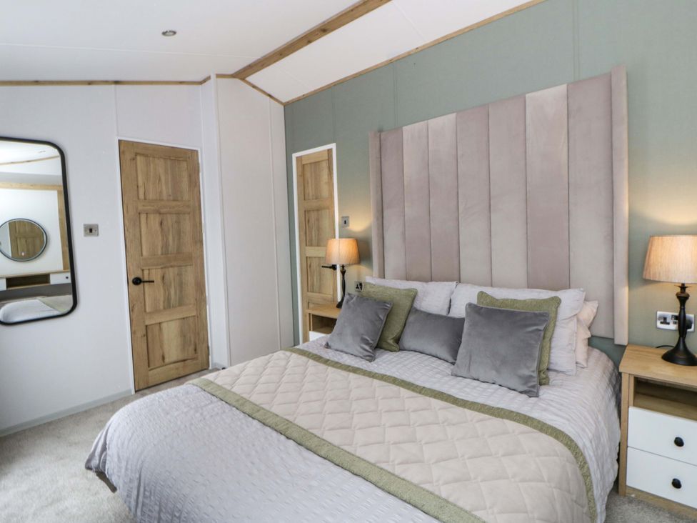 A bedroom with a bed and bedside tables at The Dorchester at Bay View New Quay