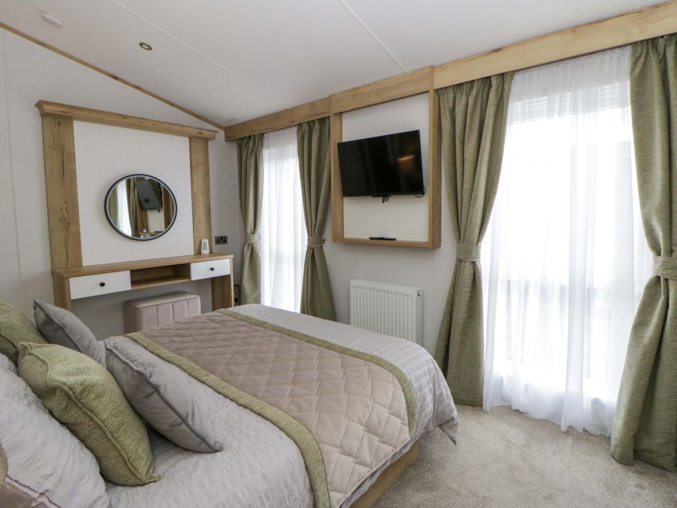 A bedroom with a bed and a desk at The Dorchester at Bay View in New Quay