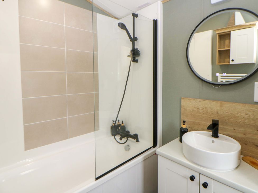 A bathroom with a bathtub and a sink at The Dorchester at Bay View, New Quay