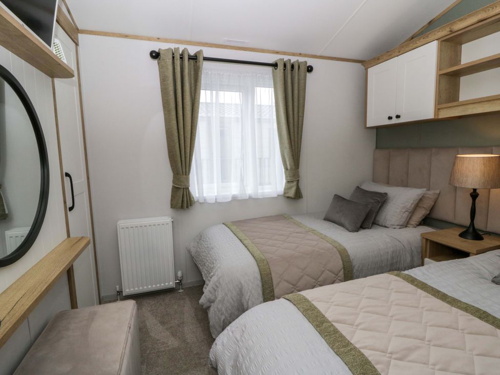 A bedroom with two beds and a window at The Dorchester at Bay View, New Quay