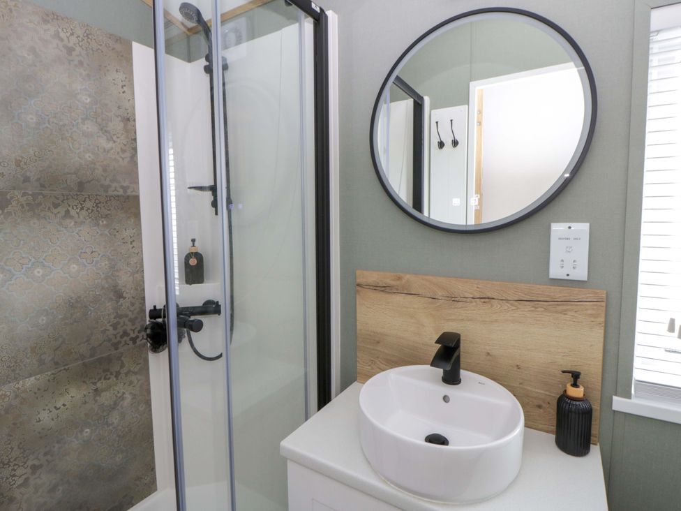 A bathroom featuring a shower and sink at The Dorchester at Bay View New Quay