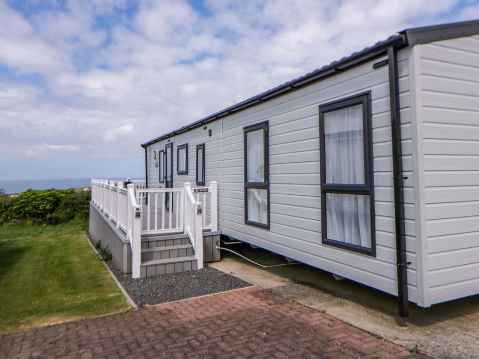 A mobile home with steps and a deck in an outdoor area at The Dorchester at Bay View in New Quay