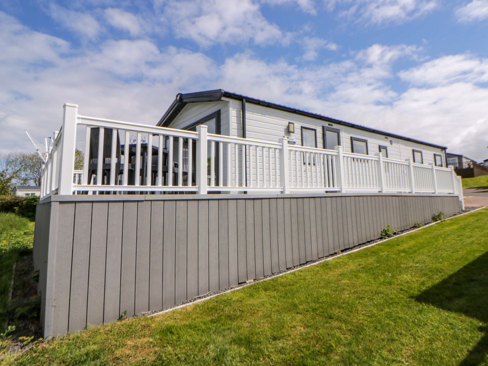 A house with a deck and railing at The Dorchester at Bay View New Quay