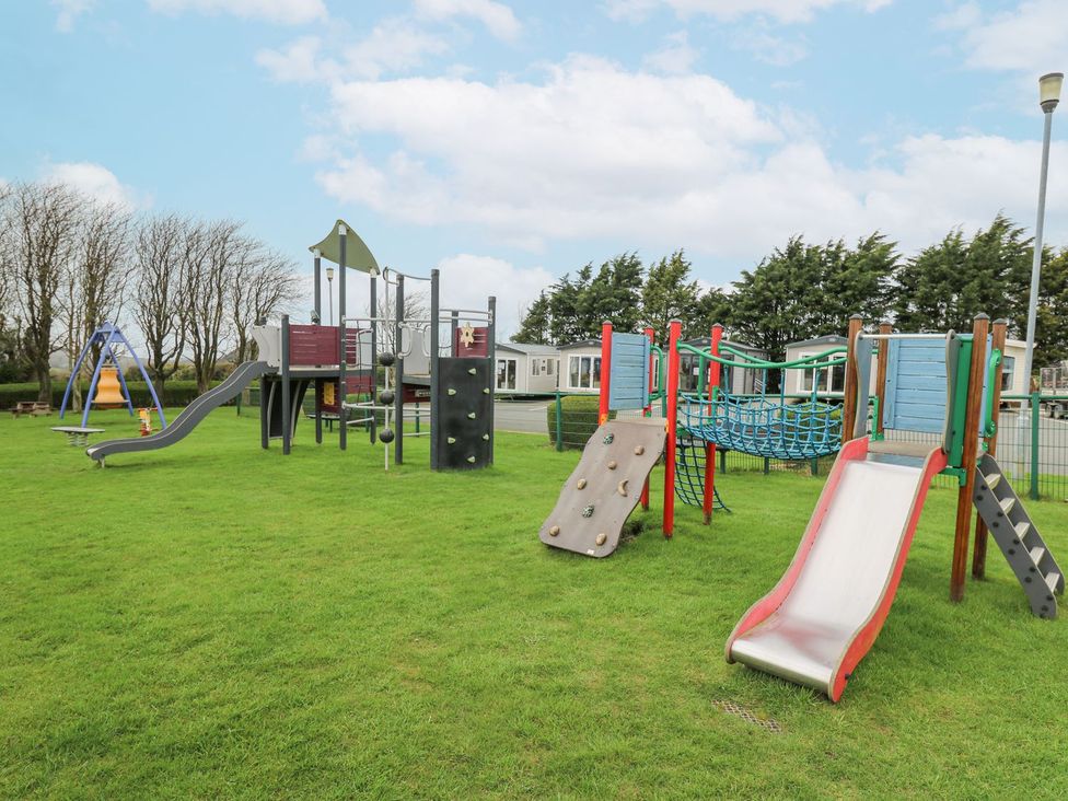 A playground with slides and climbing structures at The Dorchester at Bay View in Maen-y-groes near New Quay
