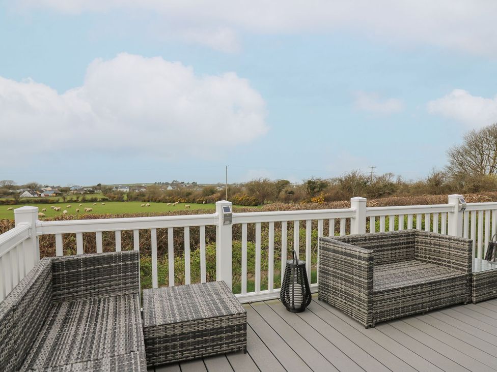 An outdoor seating area with furniture and a view of fields at The Dorchester at Bay View Maen-y-groes near New Quay