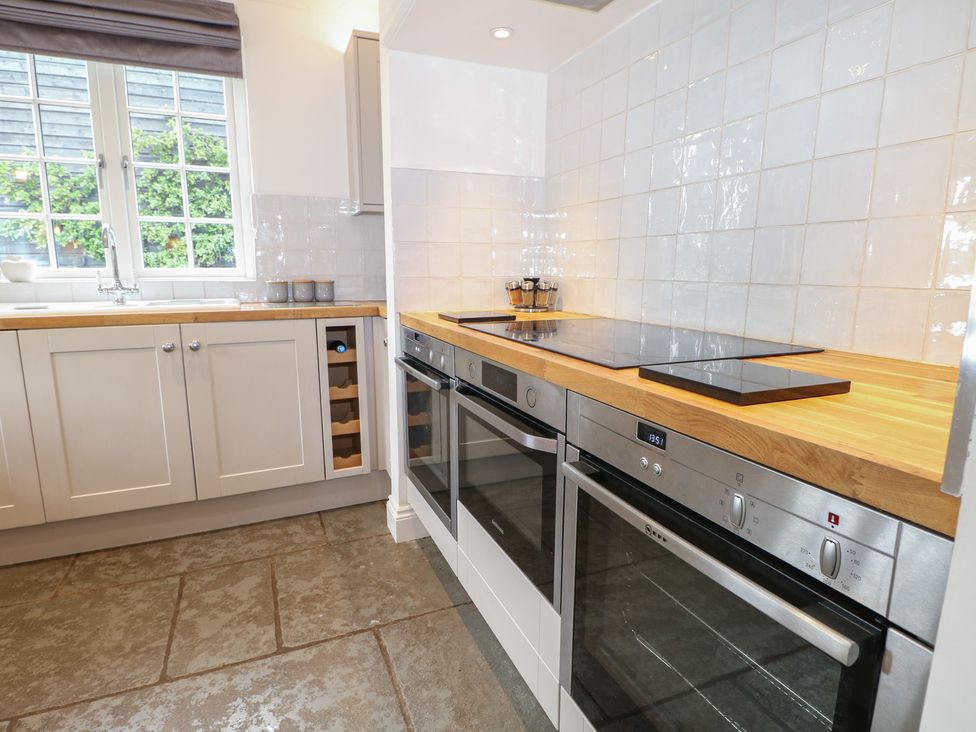 A kitchen with oven, sink, and wooden countertop at Island Cottage Rod eyot Henley-on-Thames