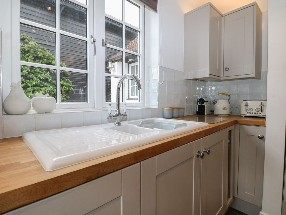 A kitchen with a sink and appliances at Island Cottage Rod eyot Henley-on-Thames