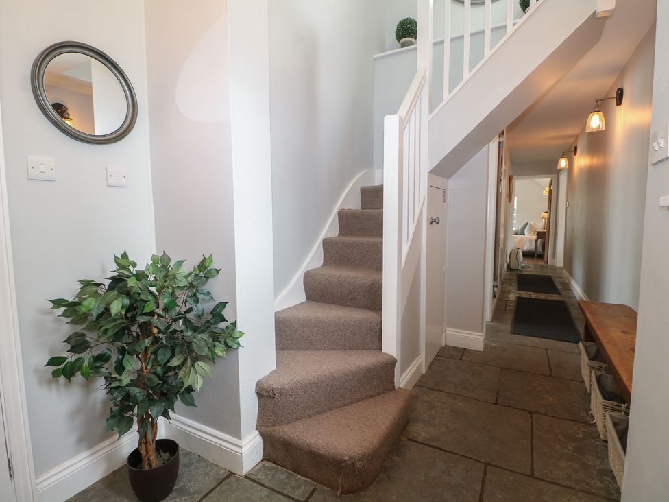A hallway with stairs and a plant at Island Cottage Rod eyot Henley-on-Thames