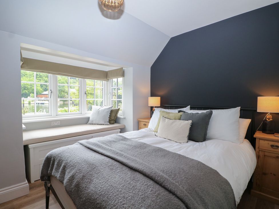 A bedroom with a bed and window seat at Island Cottage Rod eyot Henley-on-Thames