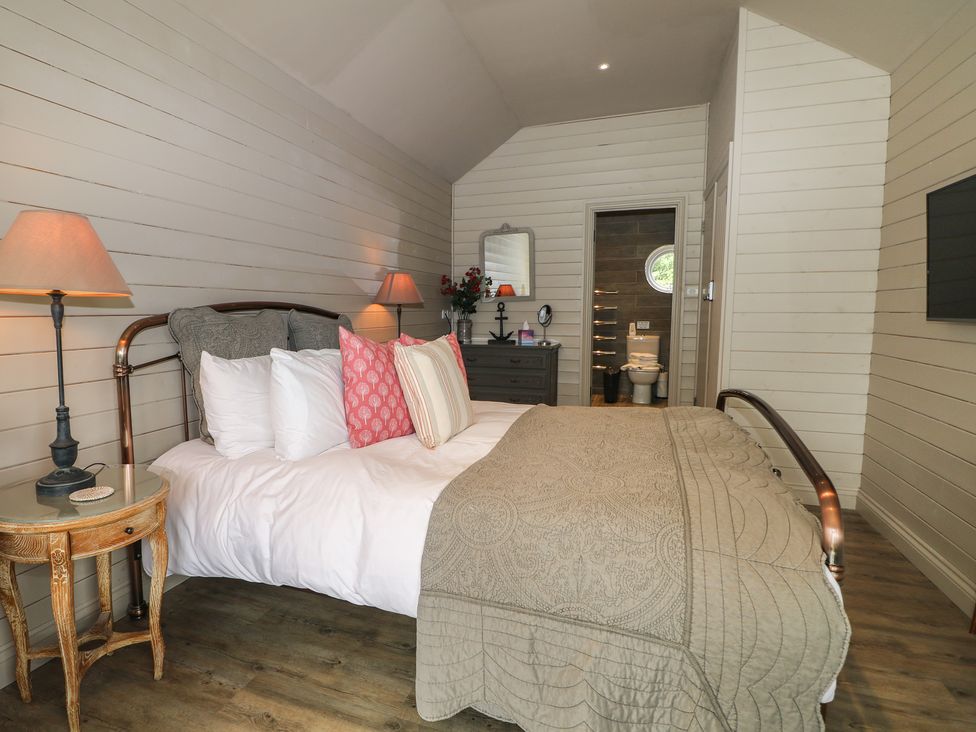 A bedroom with a bed and lamp at Island Cottage Rod eyot Henley-on-Thames