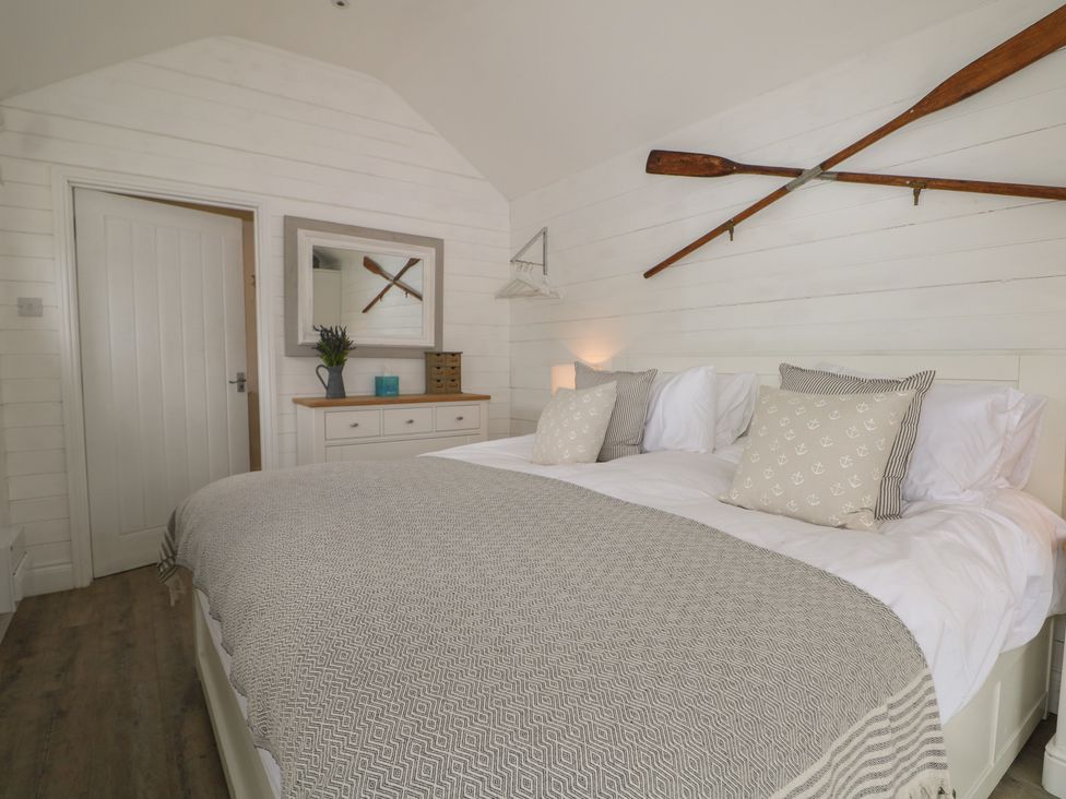 A bedroom with a bed and decorative oars at Island Cottage Rod eyot Henley-on-Thames