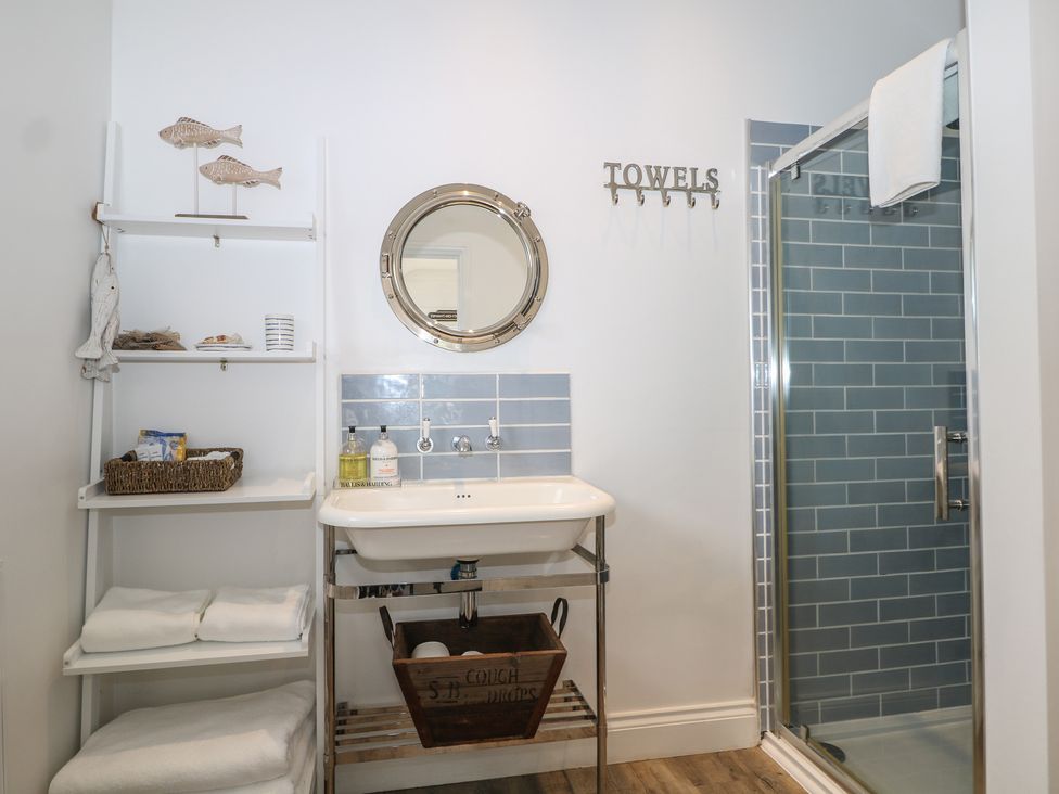 A bathroom with a sink, mirror, towel rack and shower at Island Cottage Rod eyot in Henley-on-Thames