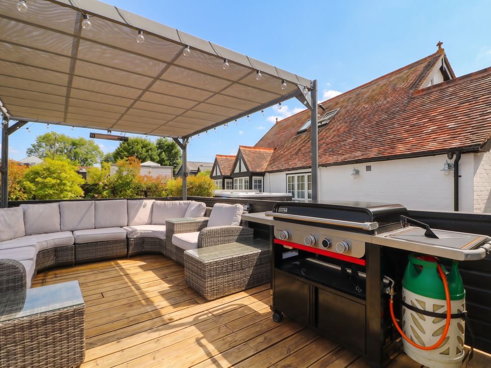 A patio with outdoor seating and a barbecue grill at Island Cottage Rod eyot Henley-on-Thames