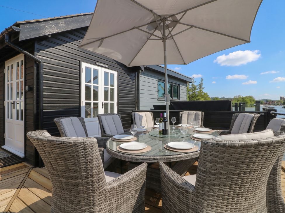 An outdoor dining area with a table and chairs at Island Cottage Rod eyot Henley-on-Thames