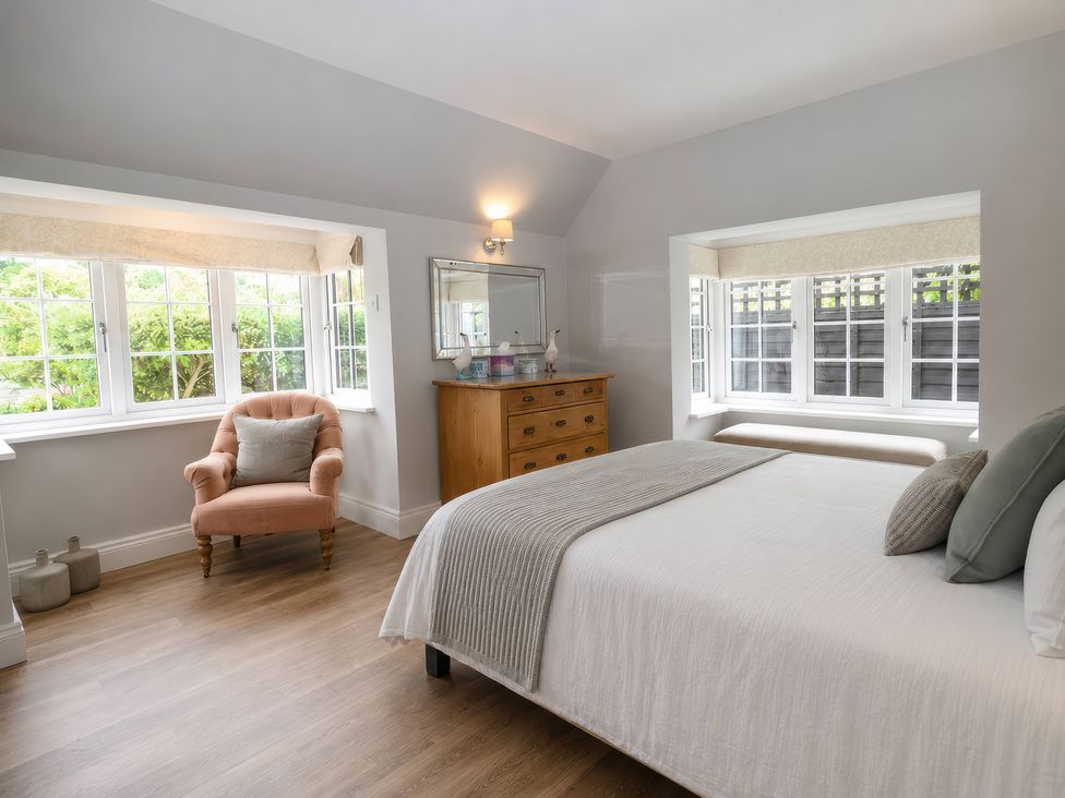 A bedroom with a bed and an armchair at Island Cottage Rod eyot Henley-On-Thames
