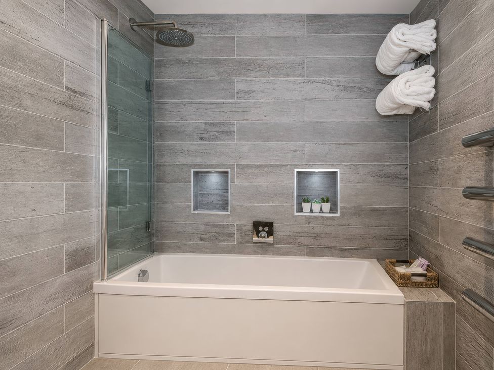 A bathroom with a bathtub and shower at Island Cottage Rod eyot in Henley-On-Thames