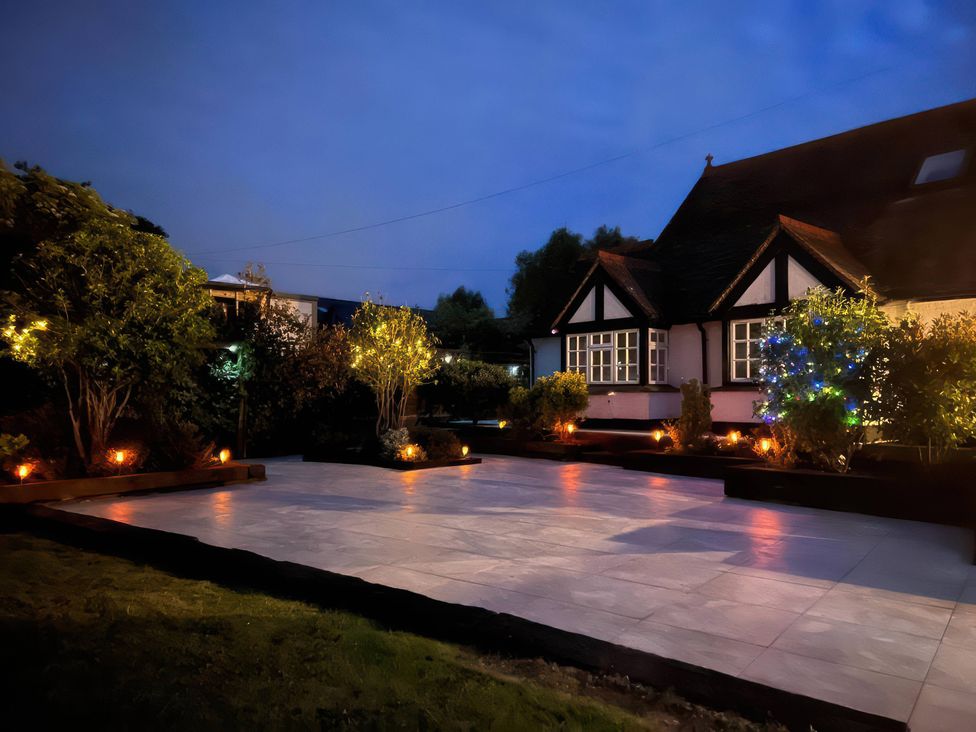 A garden with lights and a house at Island Cottage Rod eyot Henley-On-Thames