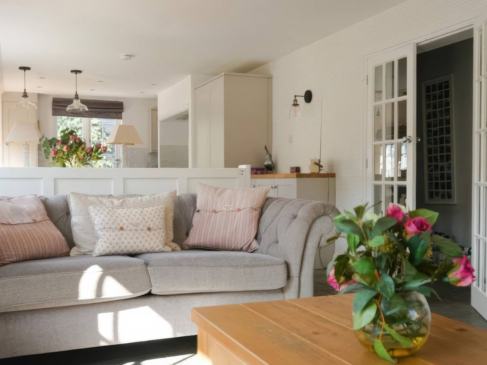 A living room with a sofa and flower vase at Island Cottage Rod eyot Henley-On-Thames