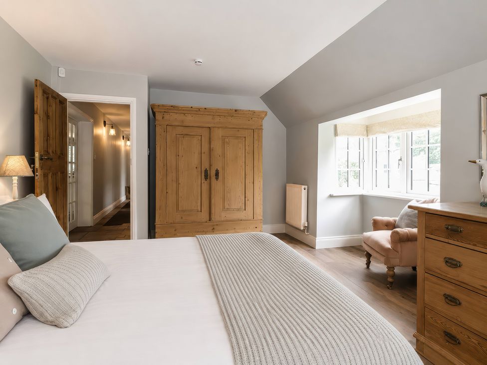 A bedroom with a bed and wardrobe at Island Cottage Rod eyot Henley-On-Thames