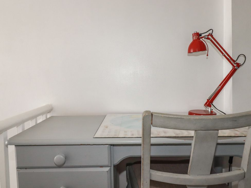 A desk with a red lamp and a chair at 39 Southgate Street
