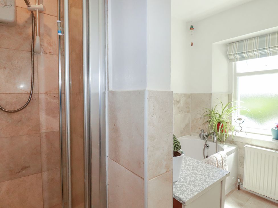 A bathroom featuring a shower, bathtub, and window at 39 Southgate Street