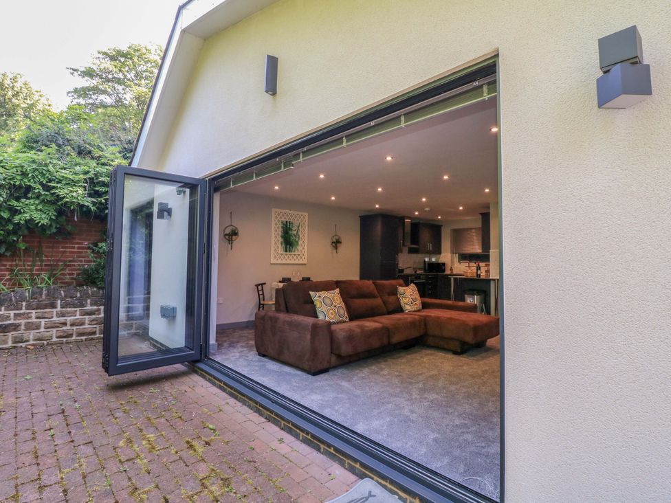 A living room with a sofa and kitchen view at Elmcroft in Nottingham