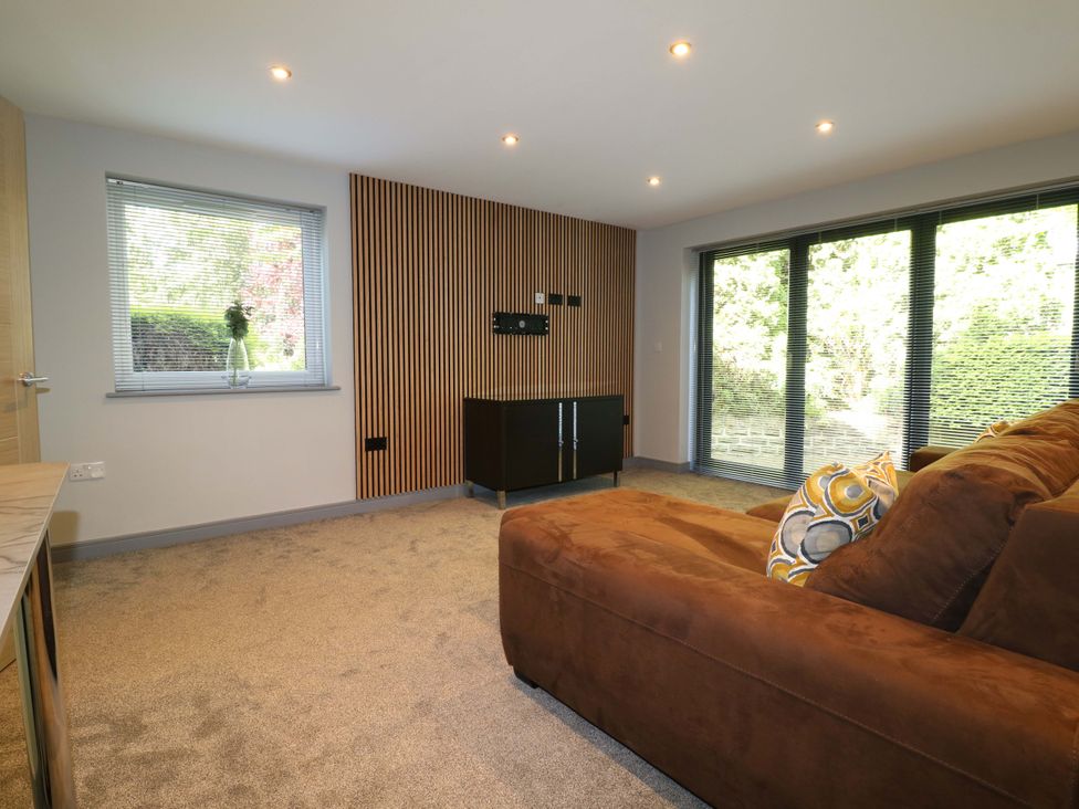 A snug with a couch, window, and sliding doors at Elmcroft in Nottingham