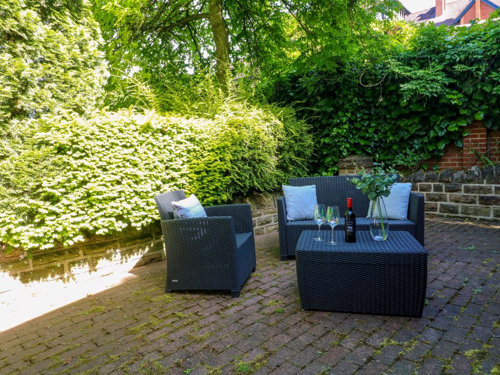 A garden with seating area and wine at Elmcroft in Nottingham