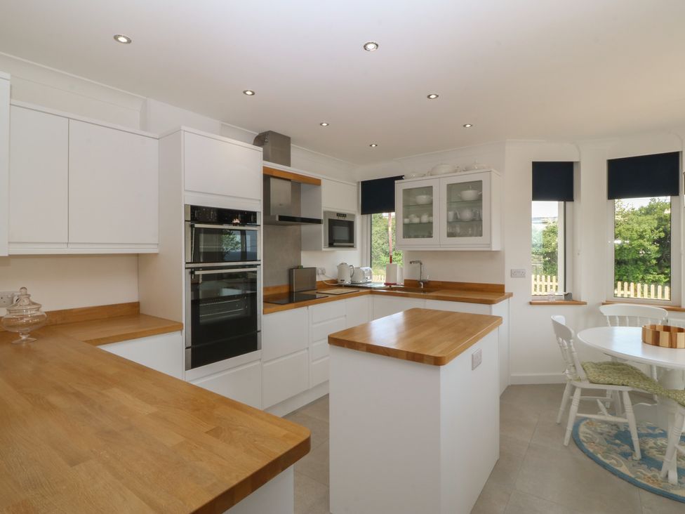 A kitchen with countertops, appliances, and a dining table at Hillside