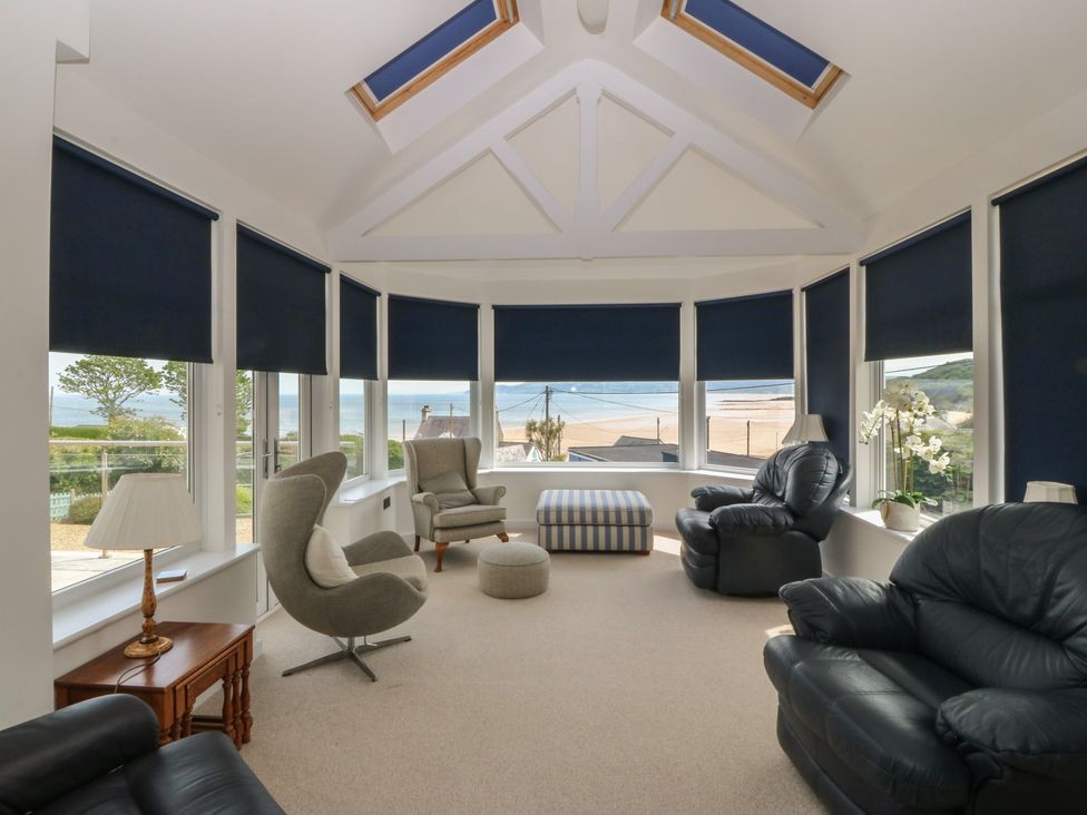 A sunroom with seating areas and windows at Hillside