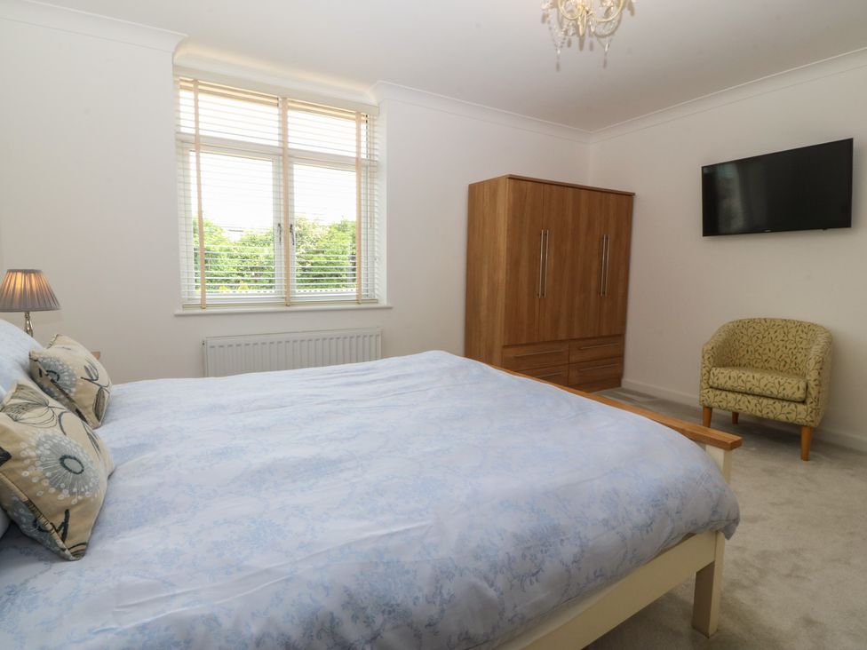 A bedroom with a bed wardrobe and television at Hillside