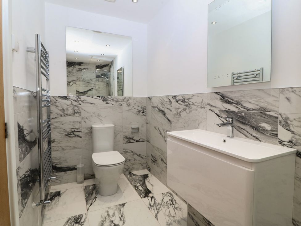 A bathroom with a toilet, sink, and mirror at Hillside